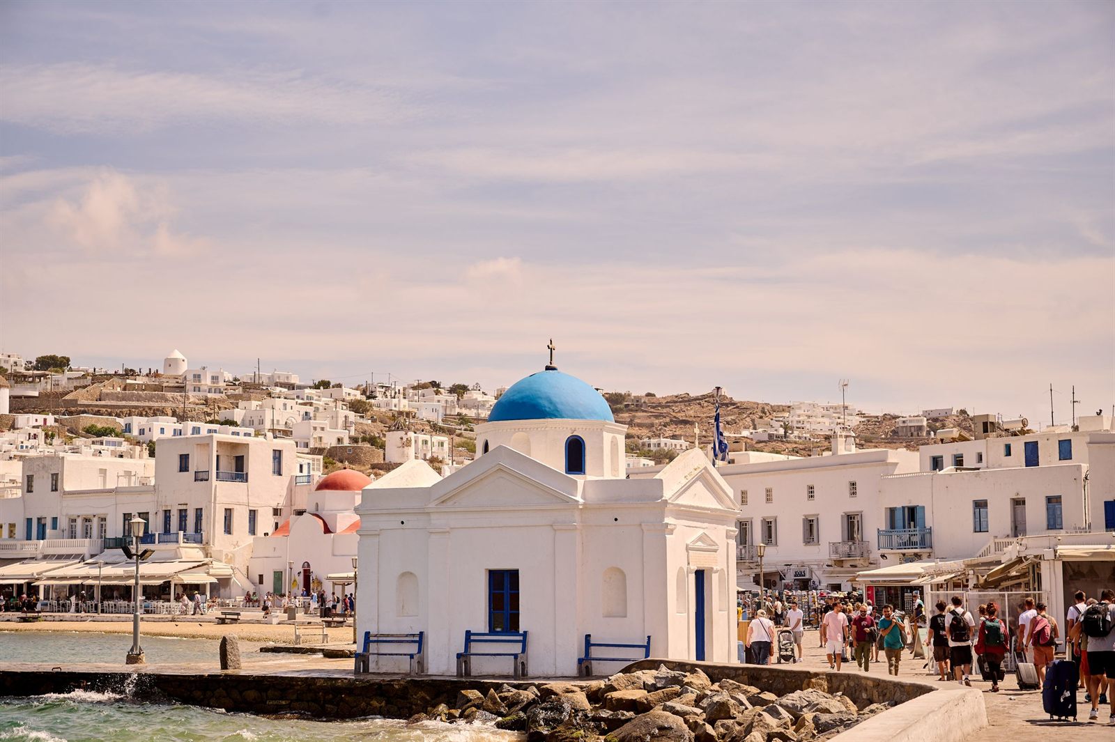 White chapel with a blue dome on the Mykonos waterfront